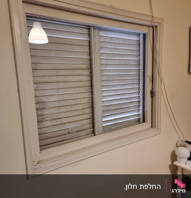 חלון עם זכוכית ותריסים סגורים